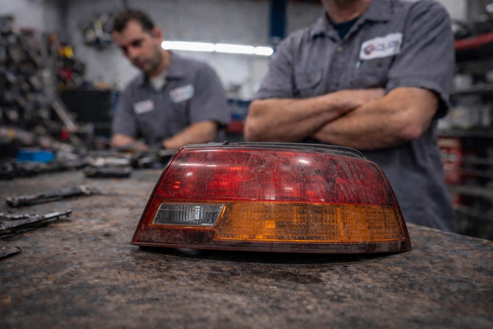 Technician inspecting used tail light assembly