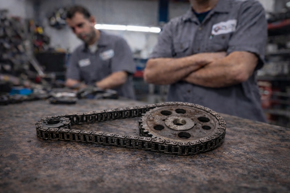 Technician inspecting used timing belt and chain